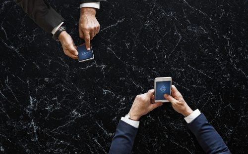 Two men in suits using smartphones