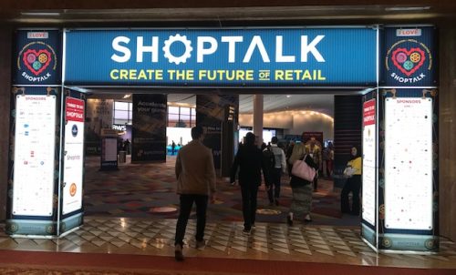 An image of attendees walking through the ShopTalk arch.